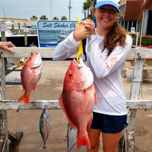 Girl with her catch on the Panama City Beach dock after a successful Saltshaker Charters fishing trip in Florida