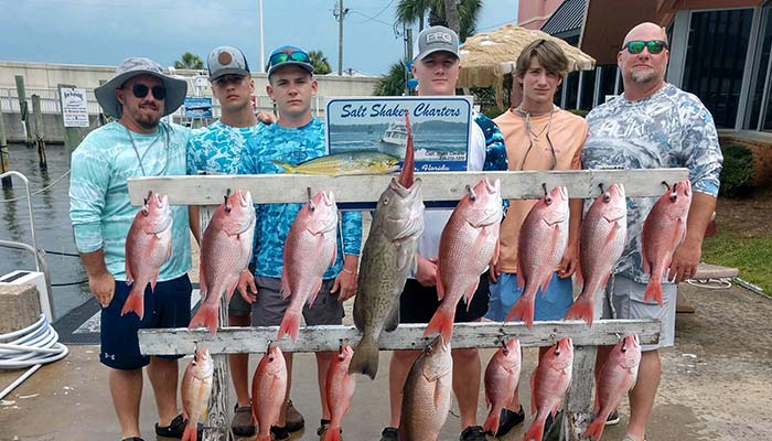 Family stands on the Panama City Beach dock after a successful Saltshaker Charters fishing trip in Florida